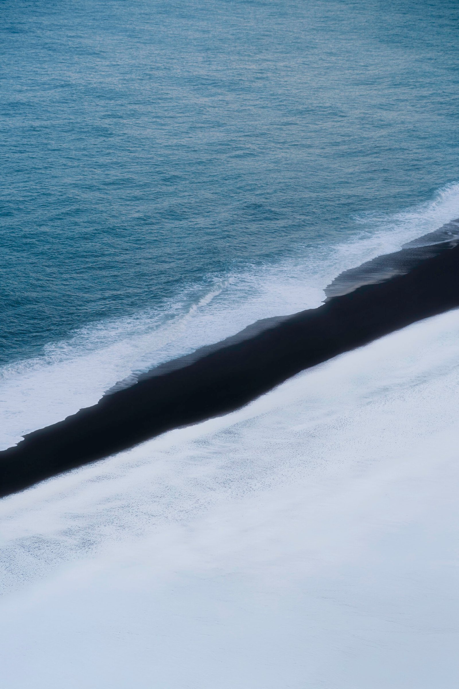 Plage au sable noir en Islande, photo artistique pour voyage et location de van