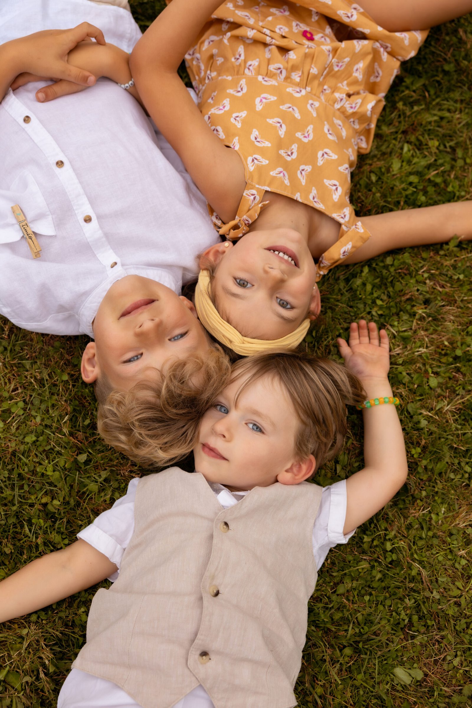 Moment tendre de trois enfants en extérieur en Normandie, capturé par Laura Xavier.
