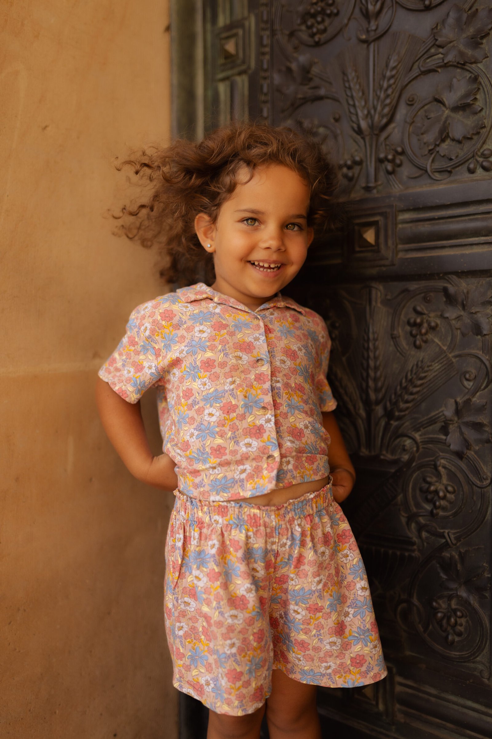 Portrait d’un enfant souriant devant une porte décorée lors d’une séance photo formule enfants