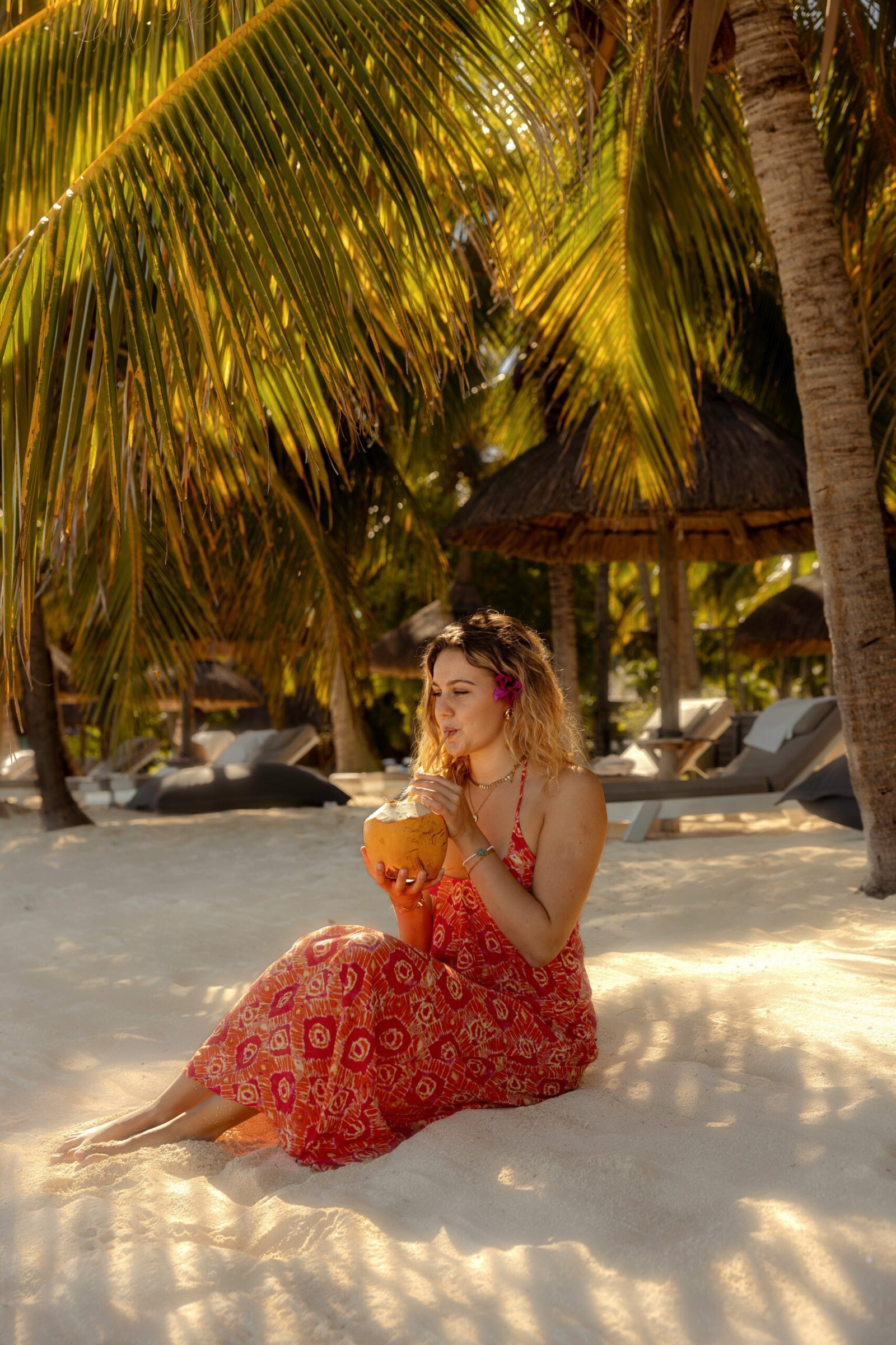 Photo de Clara dégustant une noix de coco sur la plage du Lux Le Morne à l’île Maurice pour un hôtel de luxe