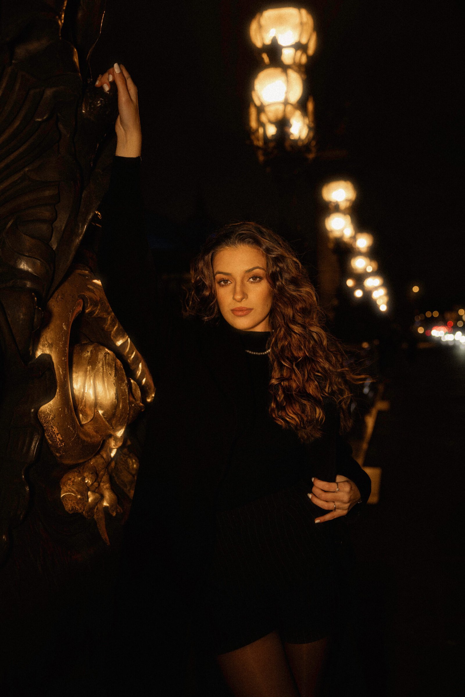 Portrait artistique d’une femme la nuit à Paris avec éclairage urbain sur le pont Alexandre III