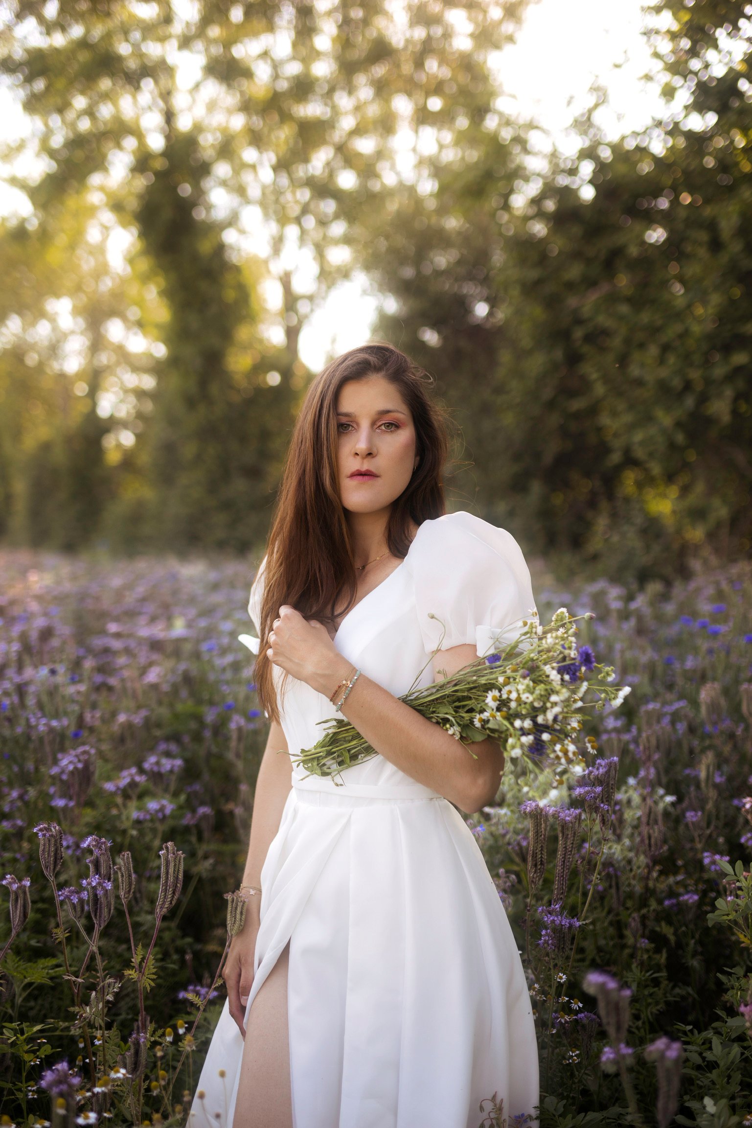 Portrait de Bérengère dans un champ en robe de mariée pour une marque