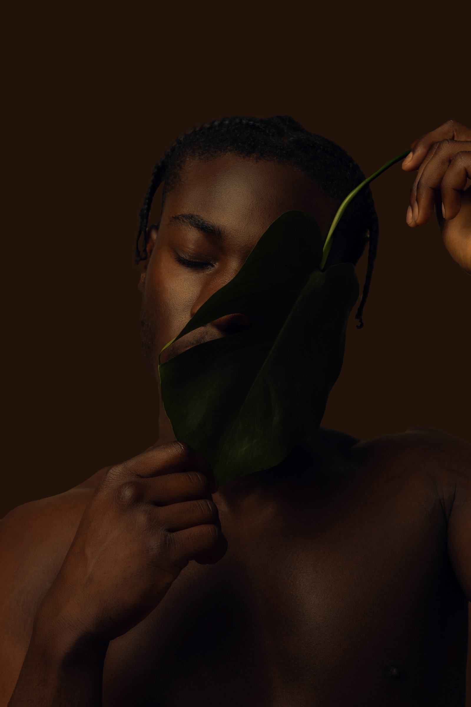 Portrait artistique de Théo en studio photo à Lyon avec une feuille tropicale